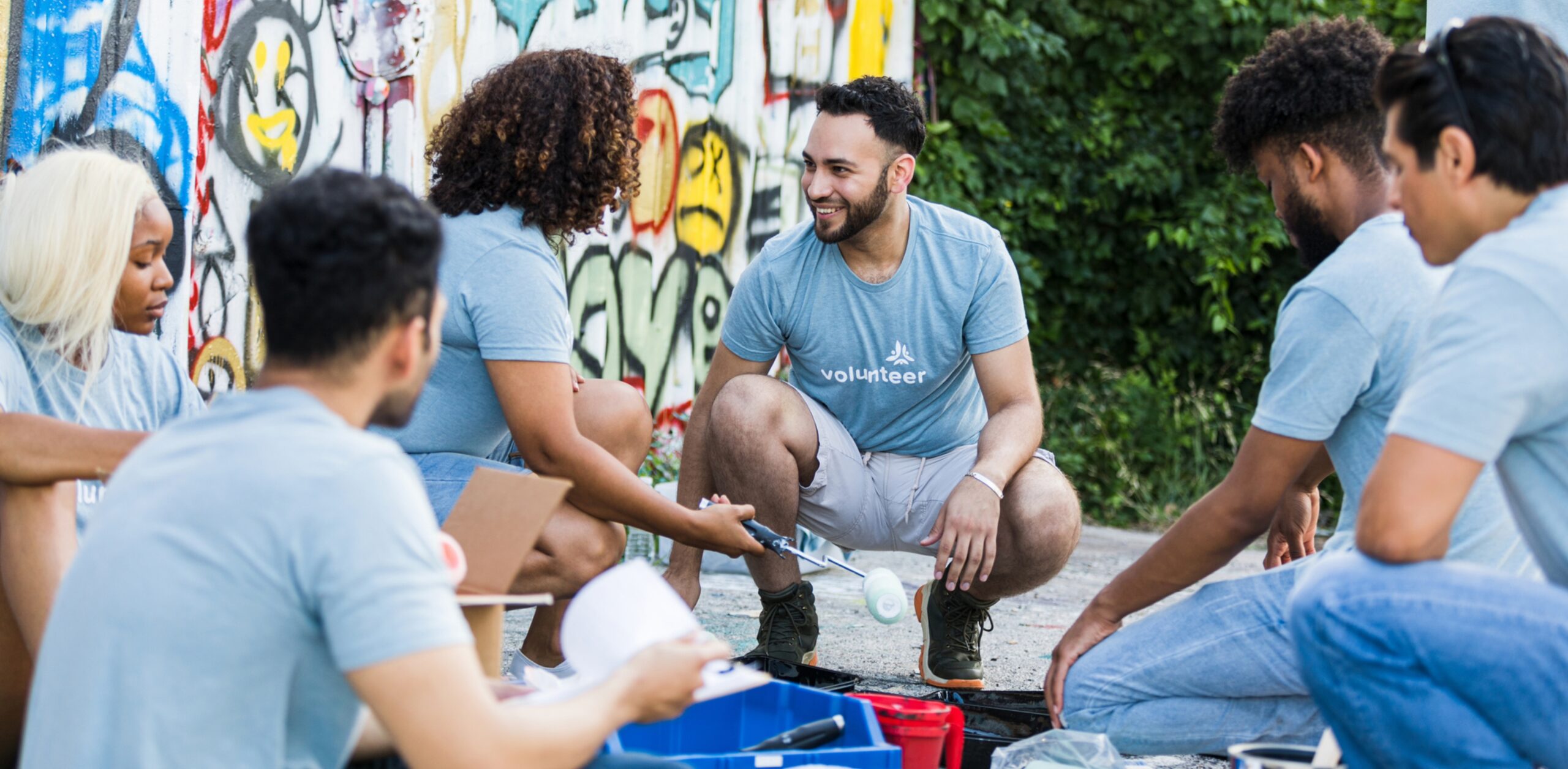 A group of people chatting while volunteering outdoors
