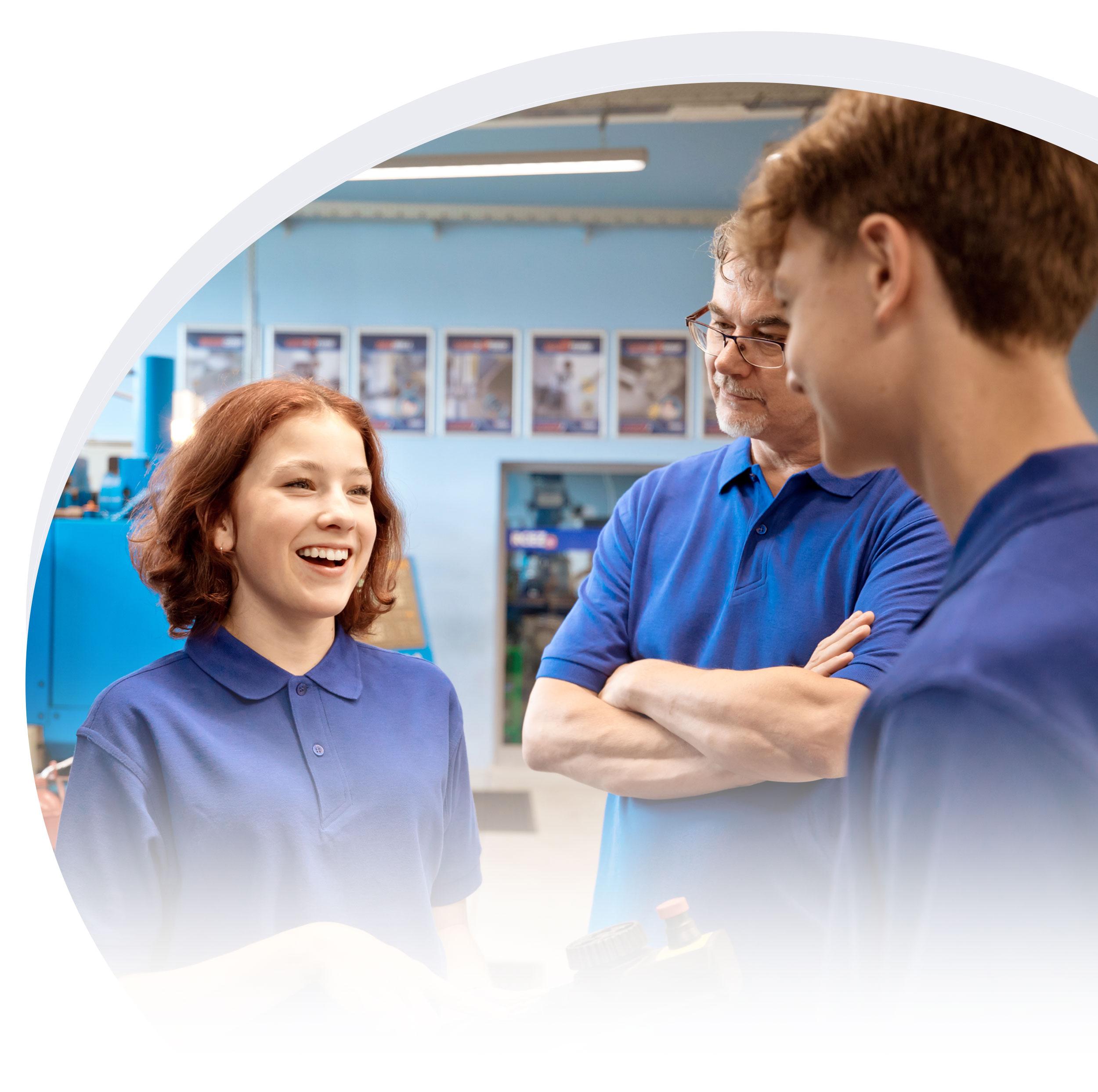 Two young technicians in training supervised by an older technician